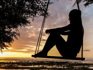 Silueta de una persona reflexionando en un columpio al atardecer, una metáfora de la introspección y el desarrollo de habilidades blandas.