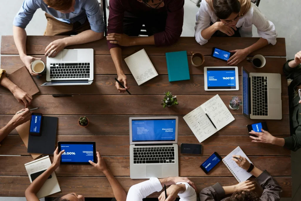 Equipo de desarrollo de software colaborando en una mesa de trabajo, destacando habilidades blandas en programación